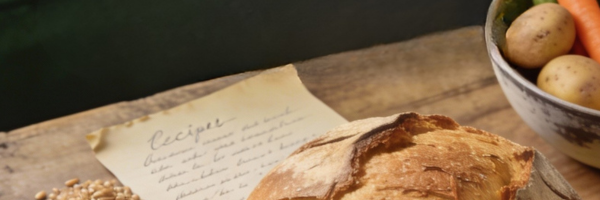 Prairie farmhouse bread and handwritten recipe on wooden table for CORR Community Cookbook supporting mental health in agriculture.